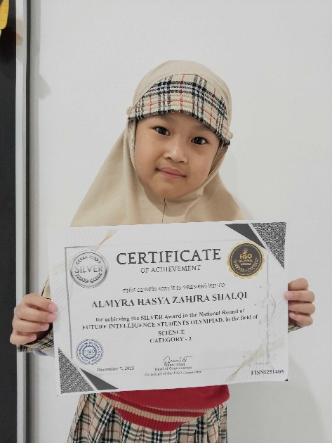 Almyra Hasya Zahira Shalqi holding her FISO Science Olympiad silver certificate