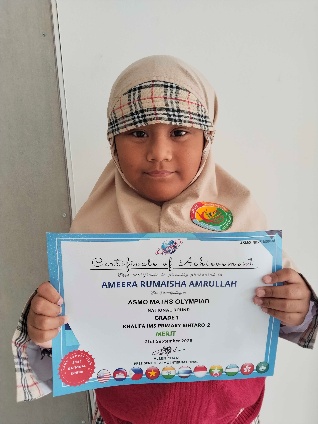 Ameera Rumaisha Amrullah holding her ASMO Math Olympiad merit certificate