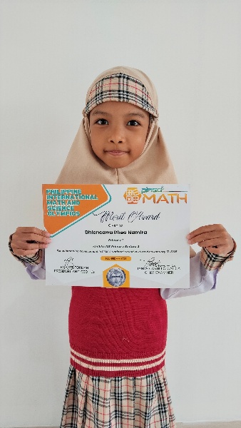Dhiencarra Rhea Namira holding her PIMSO Math Olympiad merit certificate
