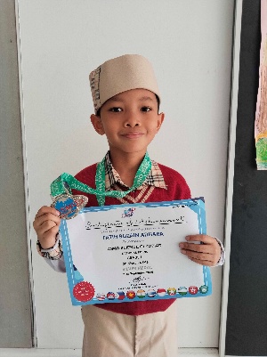 Fatih Ruzain Adhara holding his ASMO Science Olympiad silver certificate