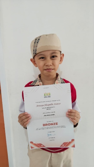 Irsyad Athaillah Ismail holding his IOB Math Olympiad certificate
