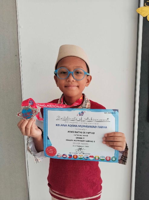 Kelana Aqsha Muhammad Farha holding his ASMO Math Olympiad silver medal