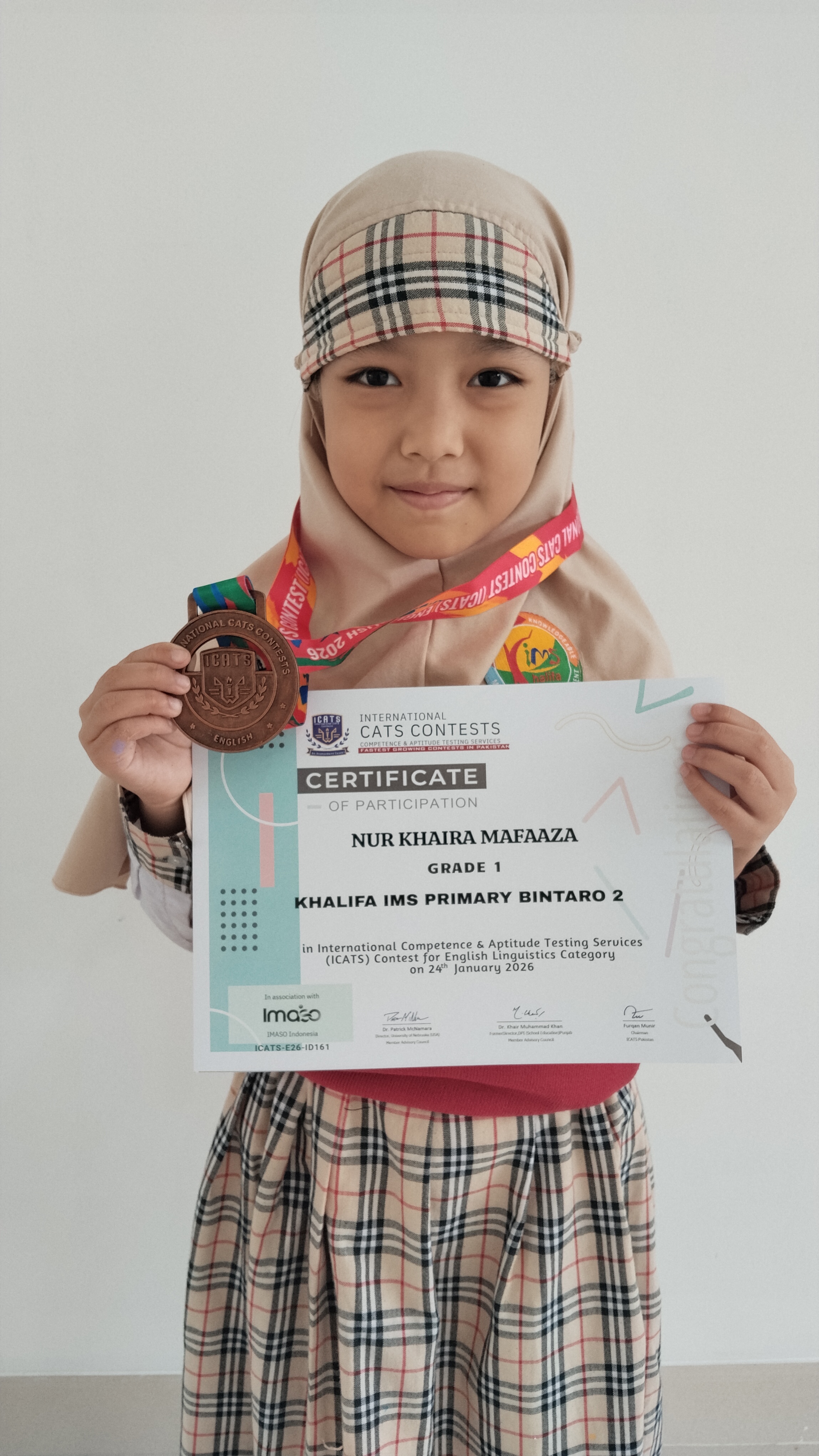 Nur Khaira Mafaaza holding her ICATS certificate and medal