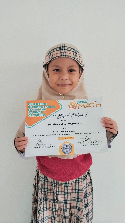 Syakira Ayleen Wicaksono holding her PIMSO Math Olympiad merit certificate
