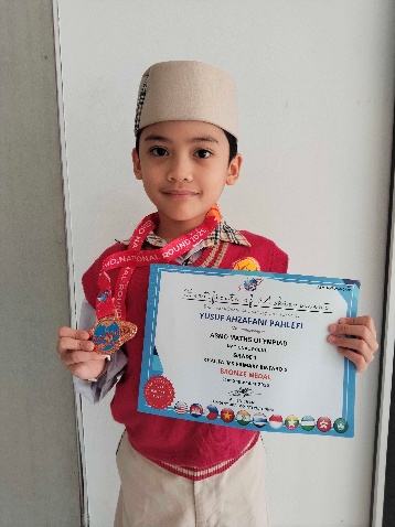 Yusuf Ahzafani Pahlefi holding his ASMO Math Olympiad bronze medal