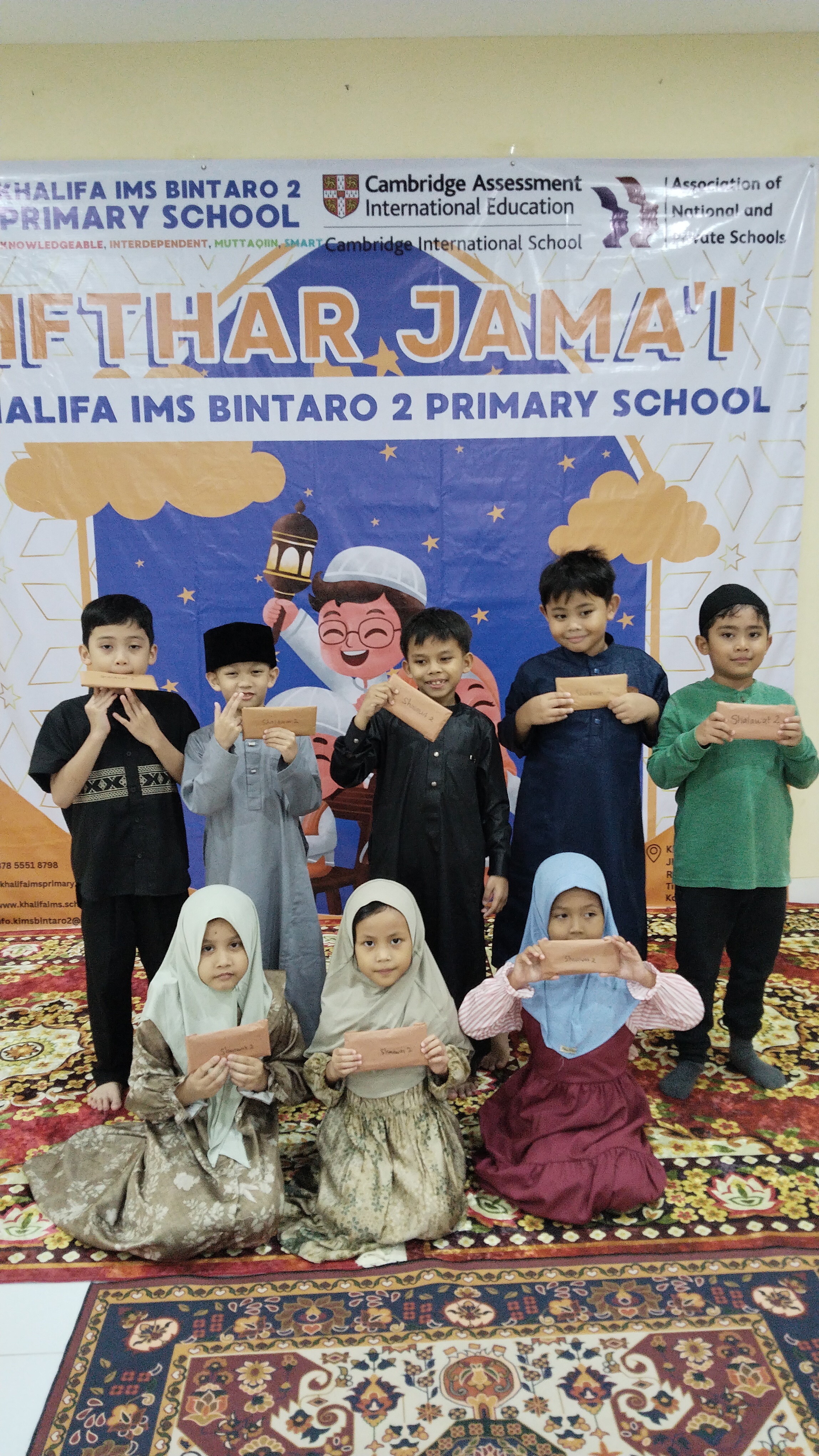 Students holding envelopes at the school's communal Iftar gathering