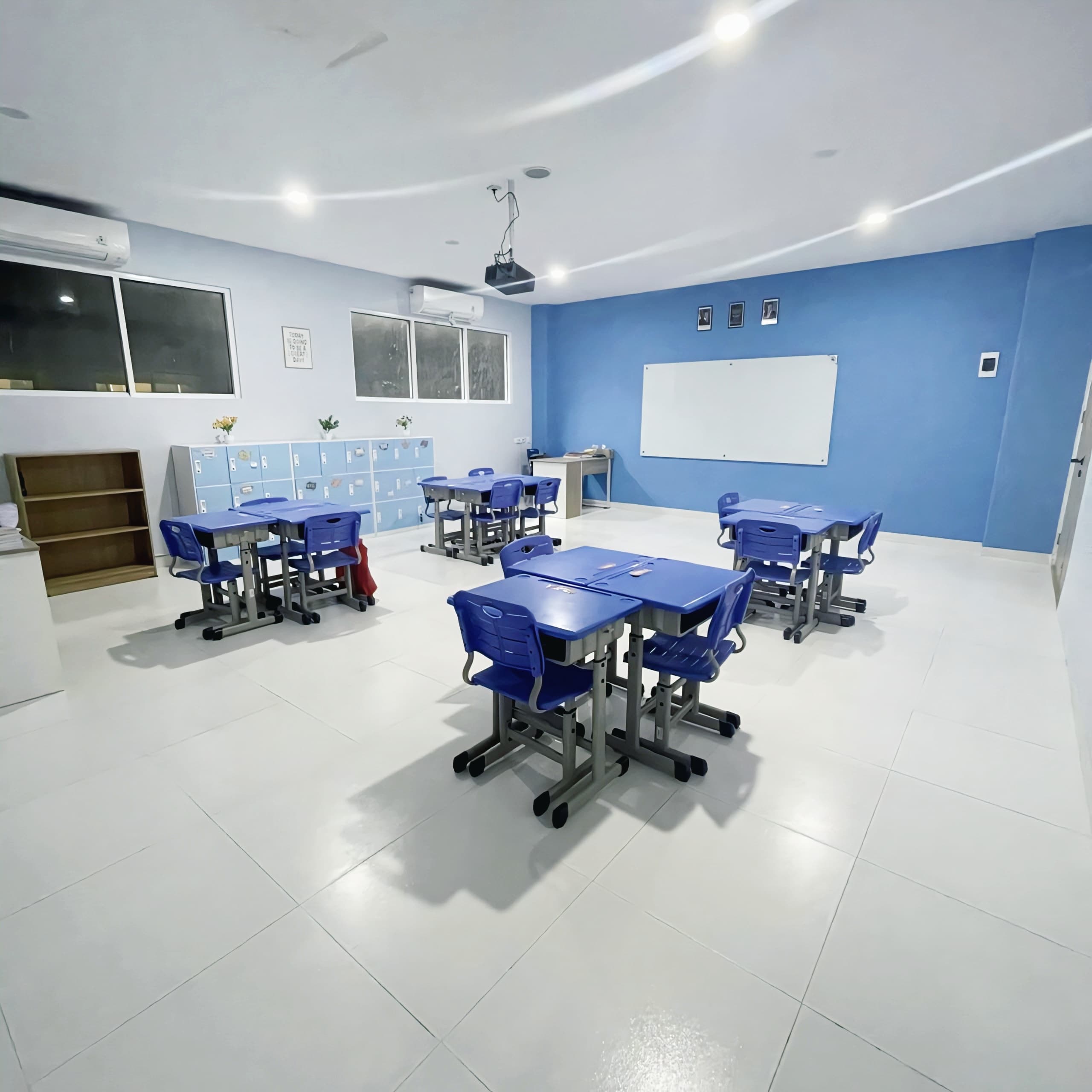 Blue-themed classroom with desks, whiteboard, and lockers