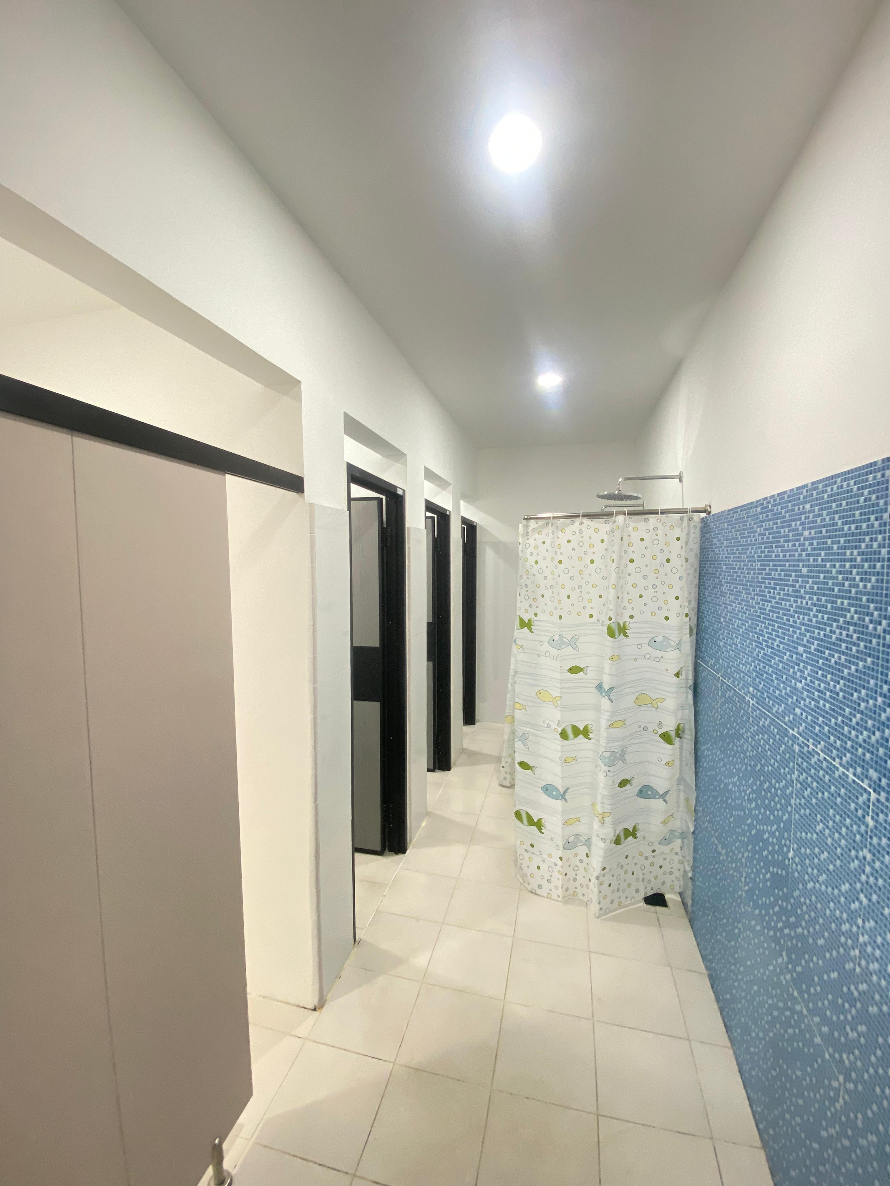 Shower room with individual stalls and a curtained shower