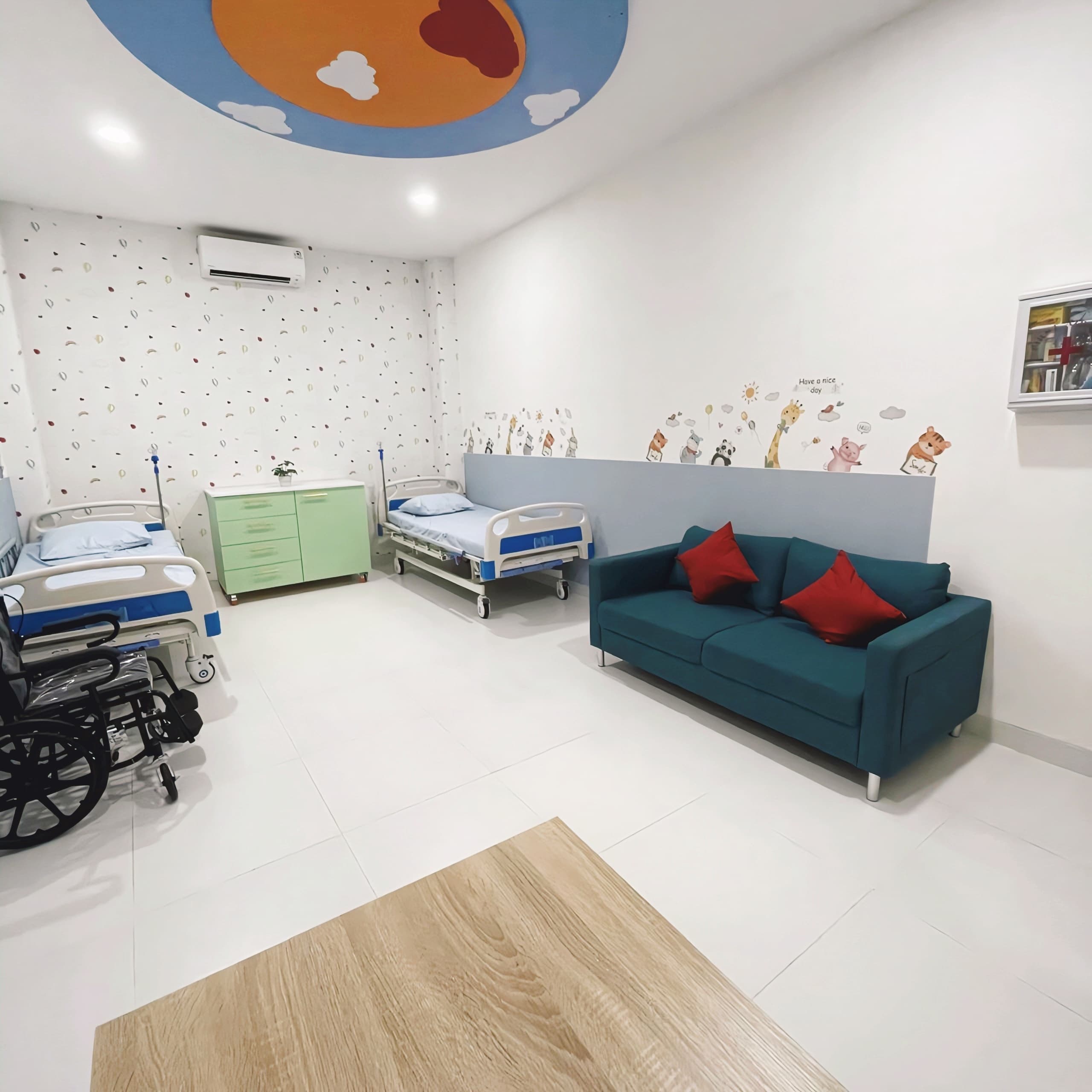 UKS school health room with beds, a wheelchair, and a sofa for waiting